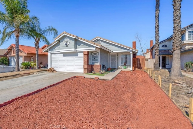 view of front of property featuring an attached garage, a tile roof, and concrete driveway