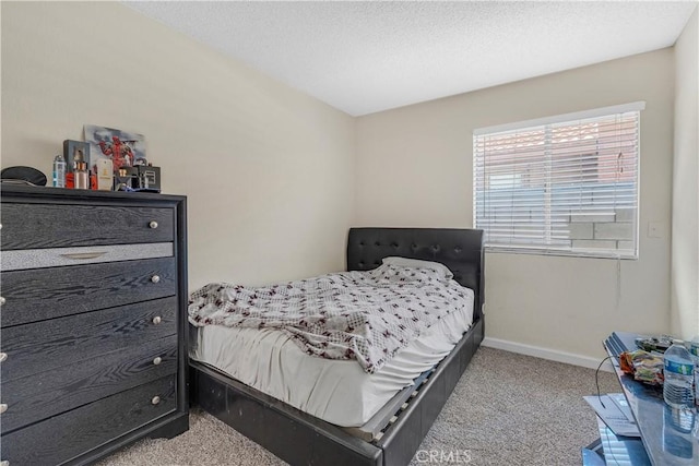 bedroom with a textured ceiling, carpet flooring, and baseboards