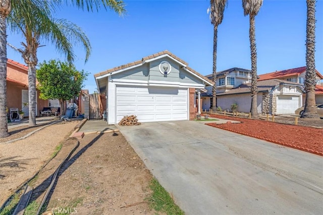 view of front of home with a garage, a tile roof, and driveway