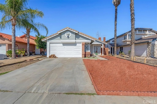 view of front of home with an attached garage, driveway, and a tile roof