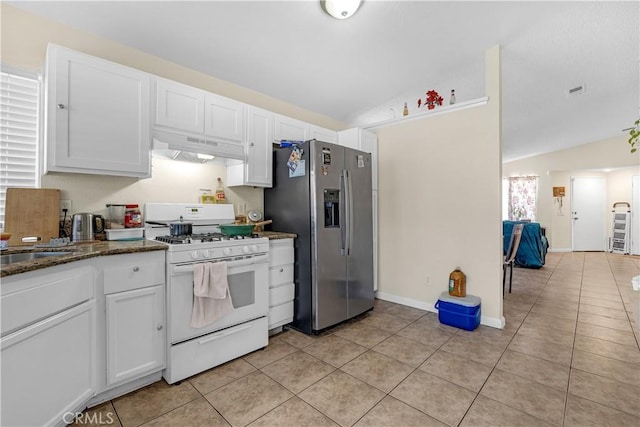 kitchen featuring light tile patterned floors, stainless steel fridge with ice dispenser, white gas range, under cabinet range hood, and white cabinetry