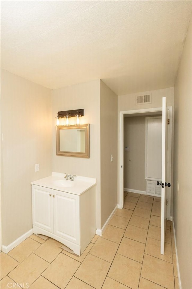 bathroom featuring tile patterned flooring, visible vents, vanity, and baseboards