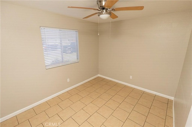 spare room with a ceiling fan and baseboards