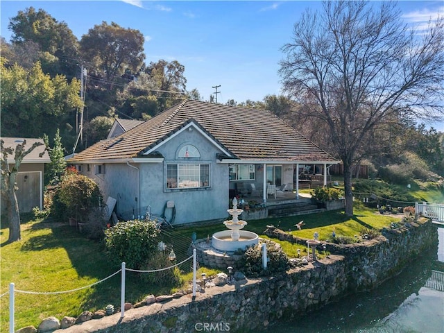 bungalow with a patio, fence, a tiled roof, stucco siding, and a front yard