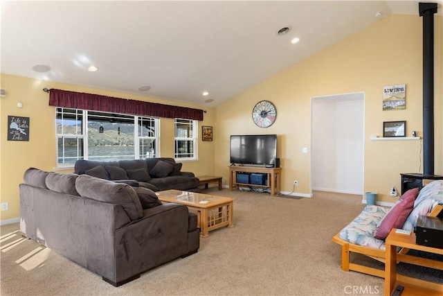 carpeted living area featuring vaulted ceiling, visible vents, a wood stove, and baseboards