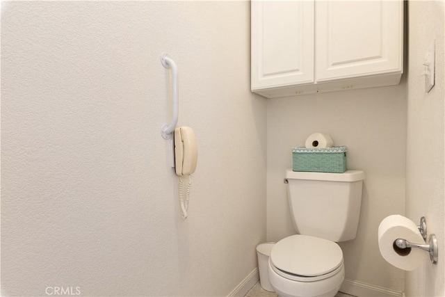 bathroom with toilet and baseboards