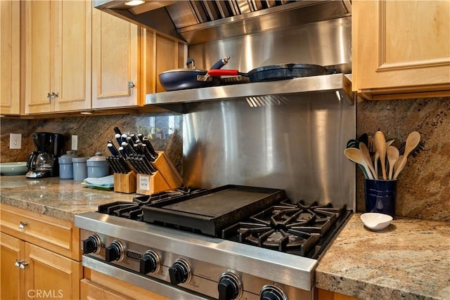 kitchen with stainless steel gas cooktop, light brown cabinetry, light stone counters, and decorative backsplash