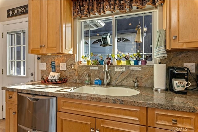 kitchen featuring stainless steel dishwasher, backsplash, and a sink