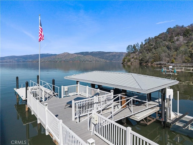 dock area with boat lift and a water and mountain view