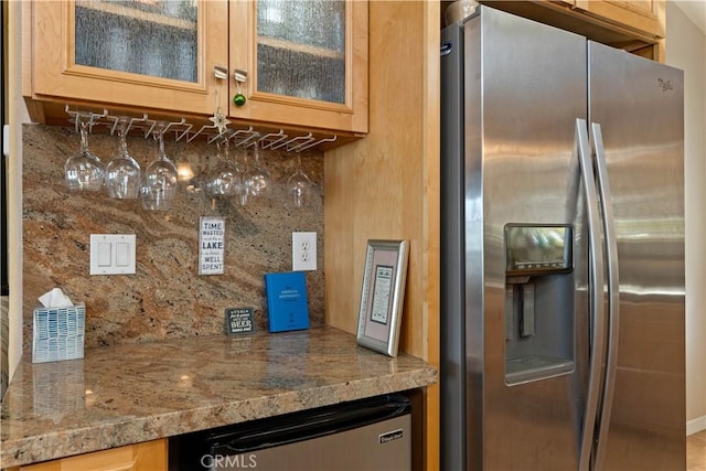 kitchen featuring tasteful backsplash, glass insert cabinets, and stainless steel fridge with ice dispenser