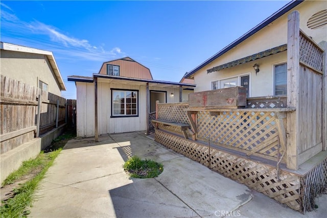 rear view of property with a patio area, fence, and a deck