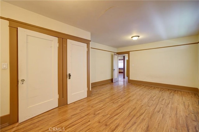 empty room featuring light wood-style flooring and baseboards