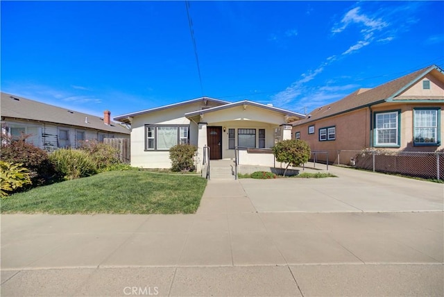 ranch-style home featuring stucco siding, a front lawn, and fence