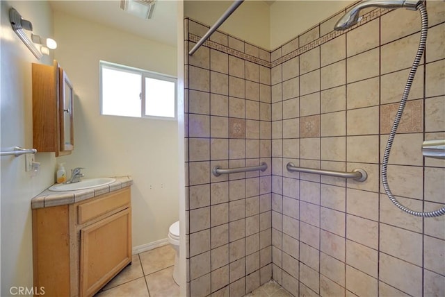 bathroom with tile patterned flooring, toilet, vanity, visible vents, and tiled shower