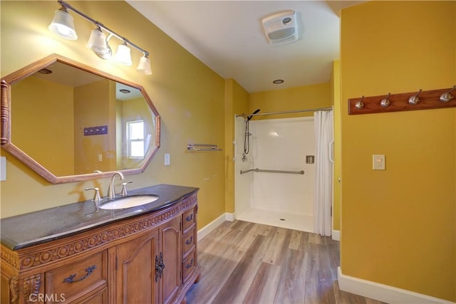 full bathroom with baseboards, wood finished floors, vanity, and a shower with curtain