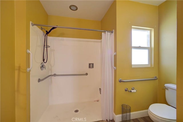 full bathroom with toilet, curtained shower, and baseboards