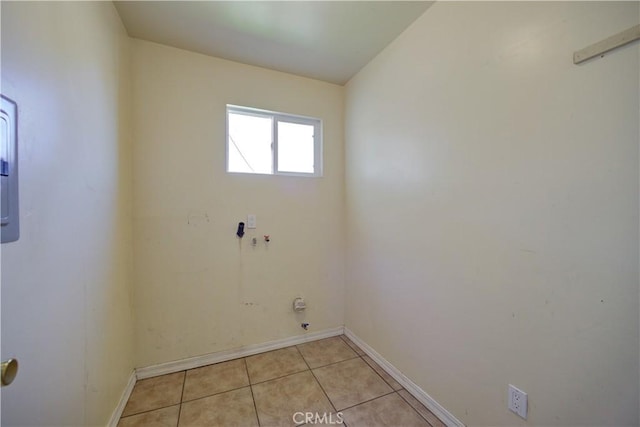 laundry room featuring laundry area, light tile patterned flooring, and baseboards