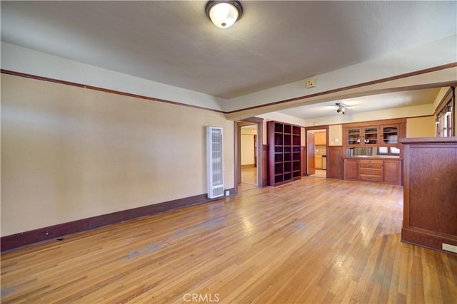 unfurnished living room with light wood-style flooring and baseboards