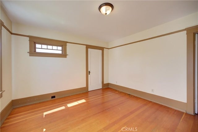 empty room with light wood finished floors and baseboards