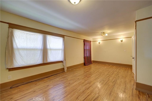 spare room with light wood-style flooring and baseboards