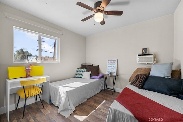 bedroom with ceiling fan, a wall mounted AC, baseboards, and wood finished floors