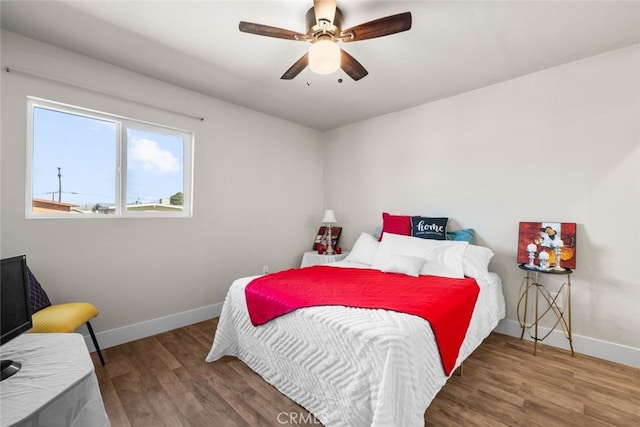 bedroom featuring ceiling fan, wood finished floors, and baseboards