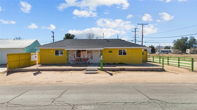 ranch-style house with fence and stucco siding