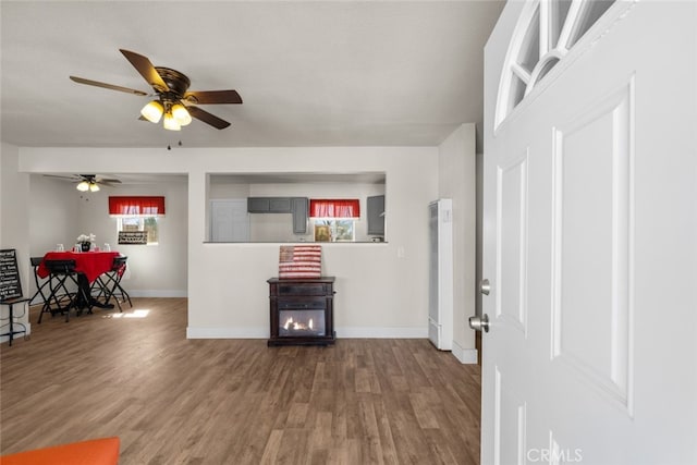 interior space featuring ceiling fan, wood finished floors, and baseboards