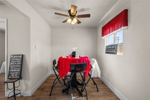 dining room featuring wood finished floors, a ceiling fan, and baseboards