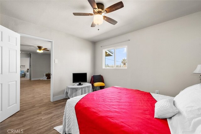 bedroom featuring ceiling fan, wood finished floors, and baseboards