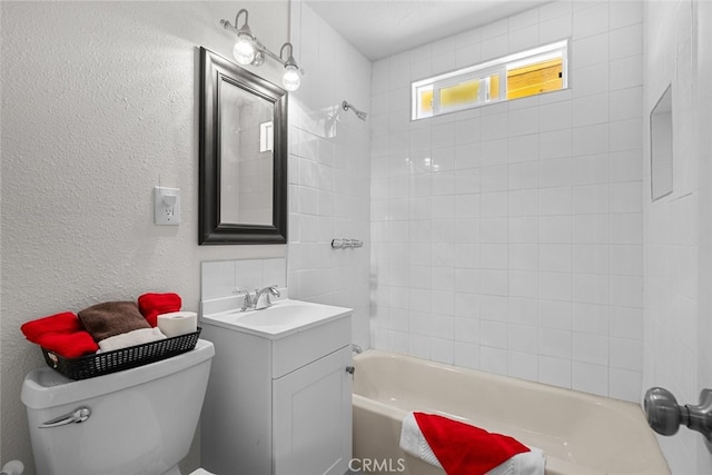 full bath with toilet, washtub / shower combination, vanity, and a textured wall