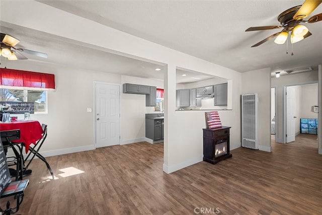 kitchen with a textured ceiling, a ceiling fan, baseboards, gray cabinets, and dark wood finished floors