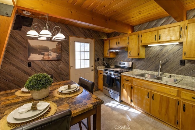 kitchen with a sink, stainless steel range with gas cooktop, beam ceiling, and under cabinet range hood