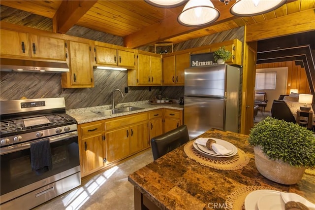 kitchen featuring appliances with stainless steel finishes, a sink, under cabinet range hood, and beamed ceiling