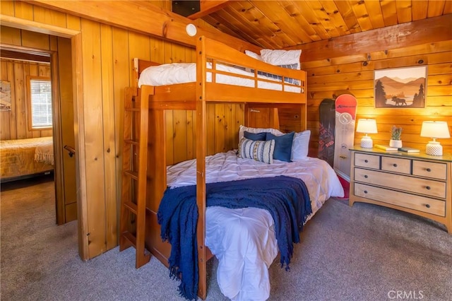 carpeted bedroom with wood ceiling and wood walls