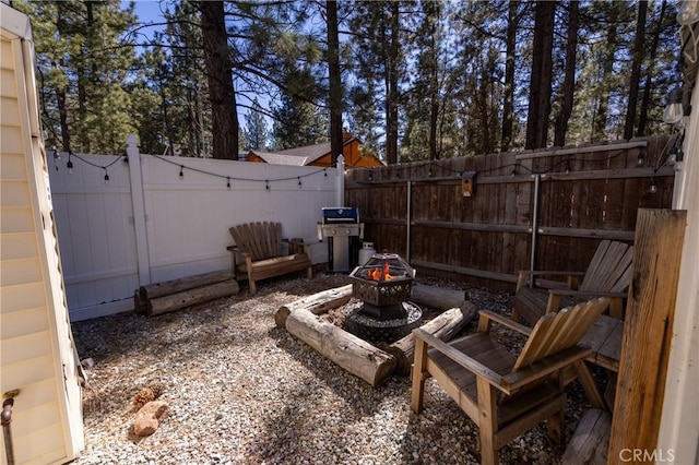 view of patio with a fenced backyard, a grill, and a fire pit