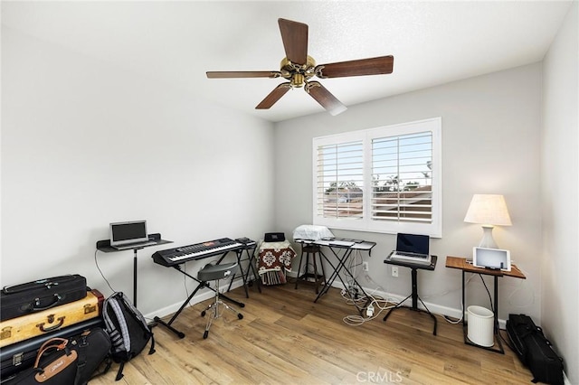 office featuring wood finished floors, a ceiling fan, and baseboards