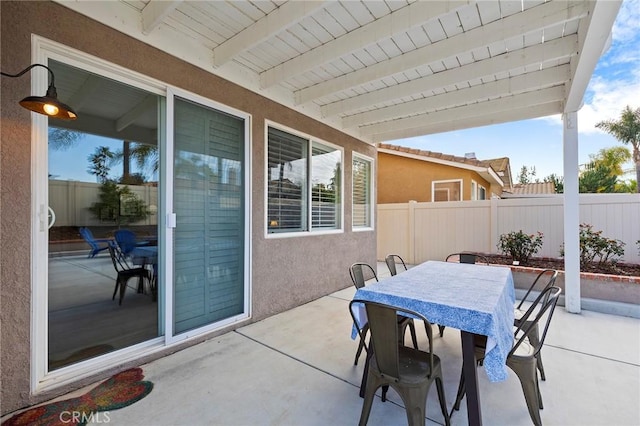 view of patio with outdoor dining area and fence