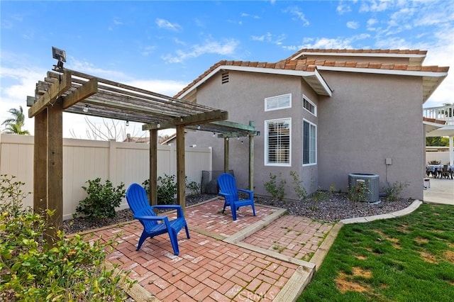 back of property with a fenced backyard, central air condition unit, a patio area, a pergola, and stucco siding