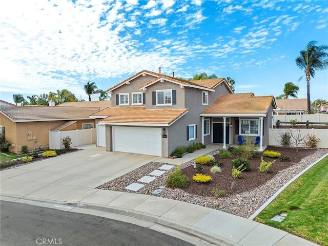 traditional-style house featuring a tile roof, stucco siding, concrete driveway, fence, and a garage