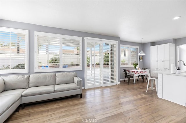 living area featuring recessed lighting, light wood-type flooring, and baseboards