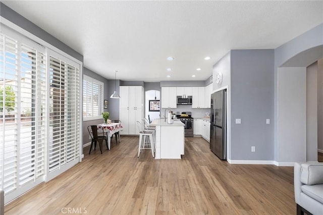 32388 Corte Palacio, Temecula, CA 92592 - kitchen featuring appliances with stainless steel finishes, open floor plan, baseboards, arched walkways, and recessed lighting