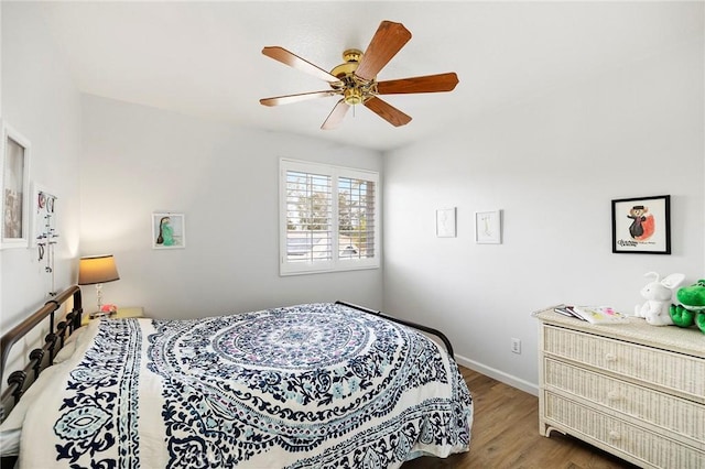 bedroom featuring a ceiling fan, baseboards, and wood finished floors