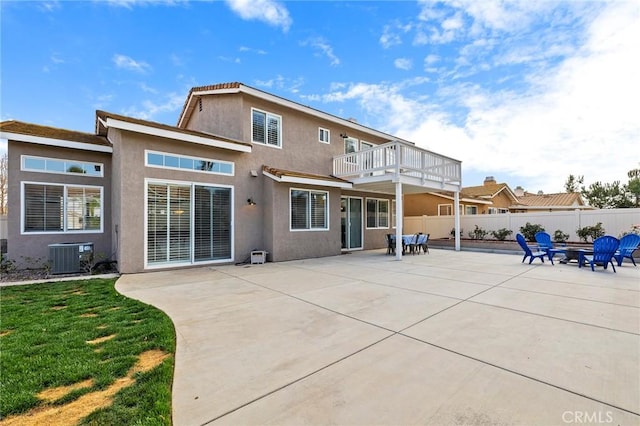 back of house with central air condition unit, fence, a lawn, stucco siding, and a patio area