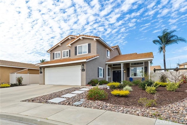 traditional-style home with an attached garage, fence, concrete driveway, a tiled roof, and stucco siding