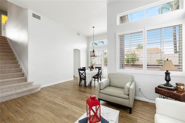 32388 Corte Palacio, Temecula, CA 92592 - living room featuring wood finished floors, arched walkways, baseboards, stairs, and a towering ceiling