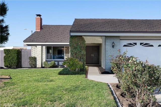 single story home featuring a garage, a front yard, a chimney, and brick siding