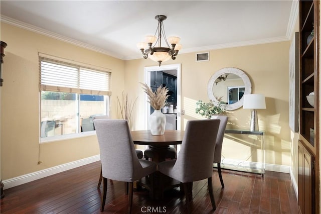 dining room featuring hardwood / wood-style flooring, baseboards, a chandelier, and ornamental molding