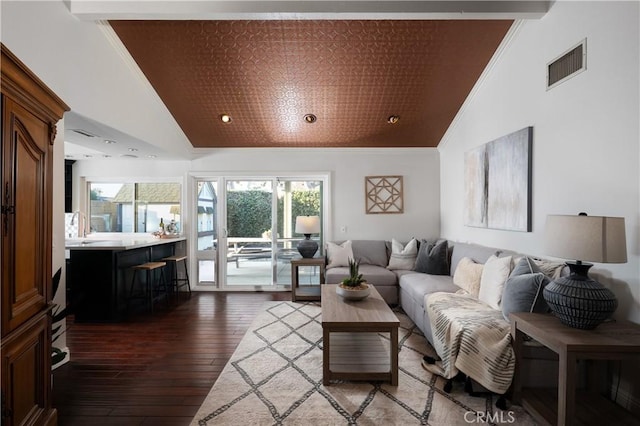 living room featuring hardwood / wood-style flooring, visible vents, and crown molding