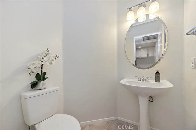 bathroom featuring a sink, tile patterned floors, toilet, and baseboards